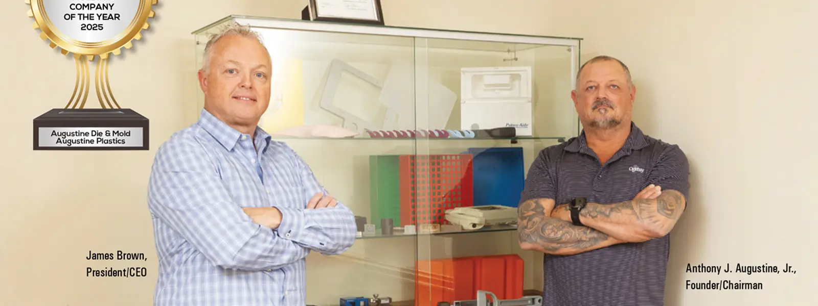 Augustine's President and CEO James Brown and Founder and Chairman Anthony J. Augustine Jr. standing to celebrate receiving award for company of the year Precision Machining/Plastics Injection Molding company of the year 2025
